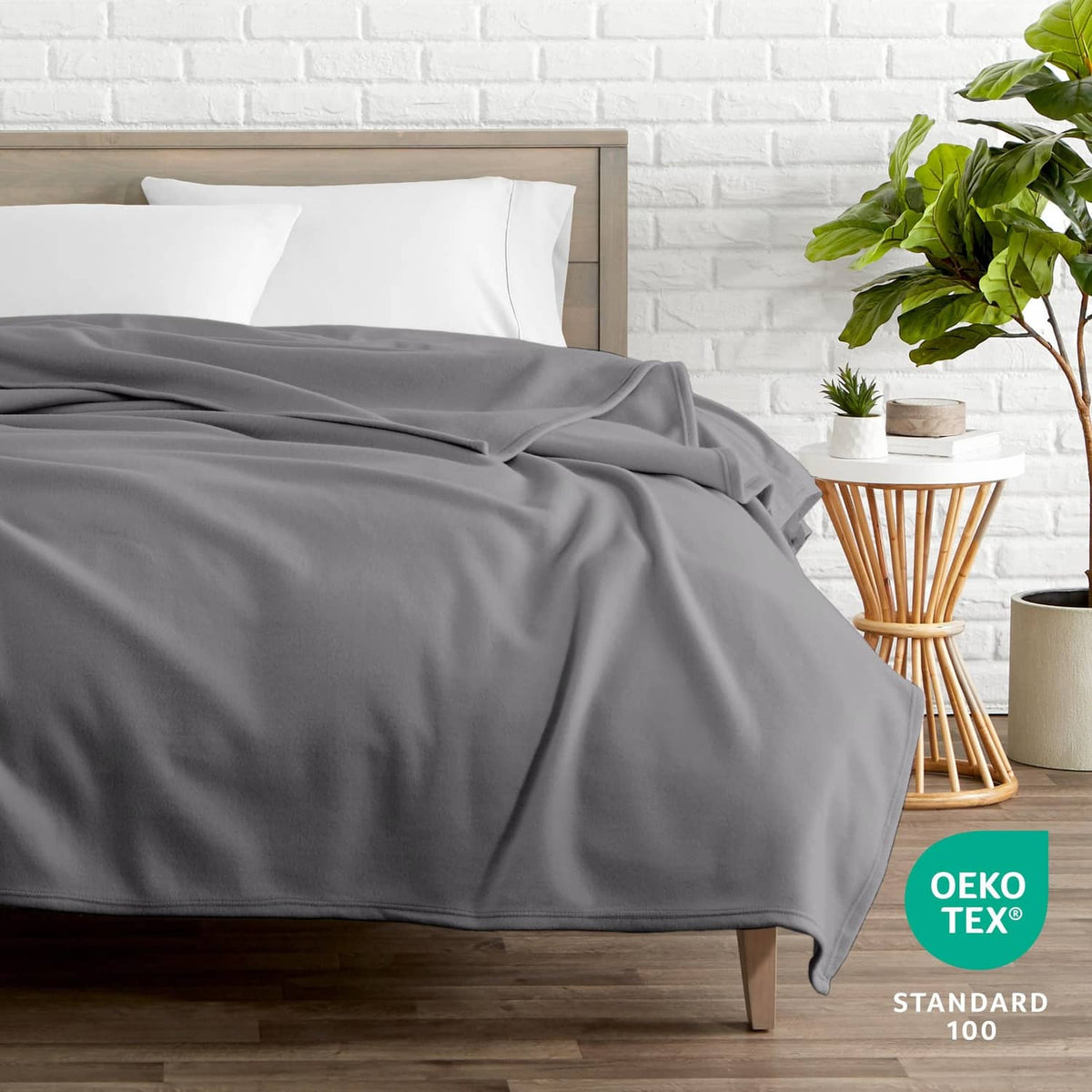 Gray full/queen blanket neatly spread across a bed, smooth woven texture