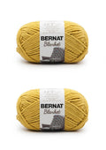 Two yellow Bernat Blanket yarn skeins with labels on a clean background.