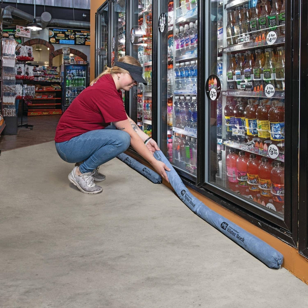 Blue absorbent sock barrier being placed along a refrigerator door opening