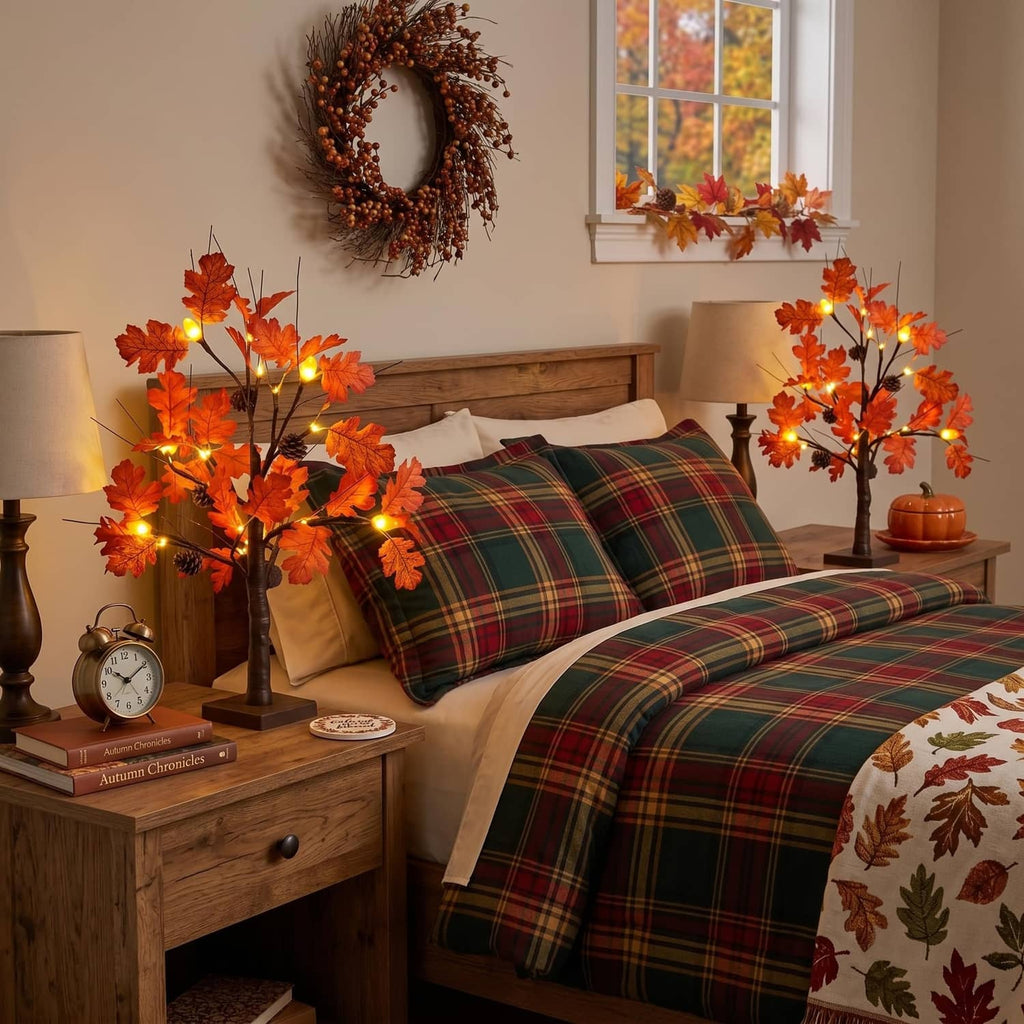 Lighted fall acorn tree decorations with orange leaf lights beside a plaid bed