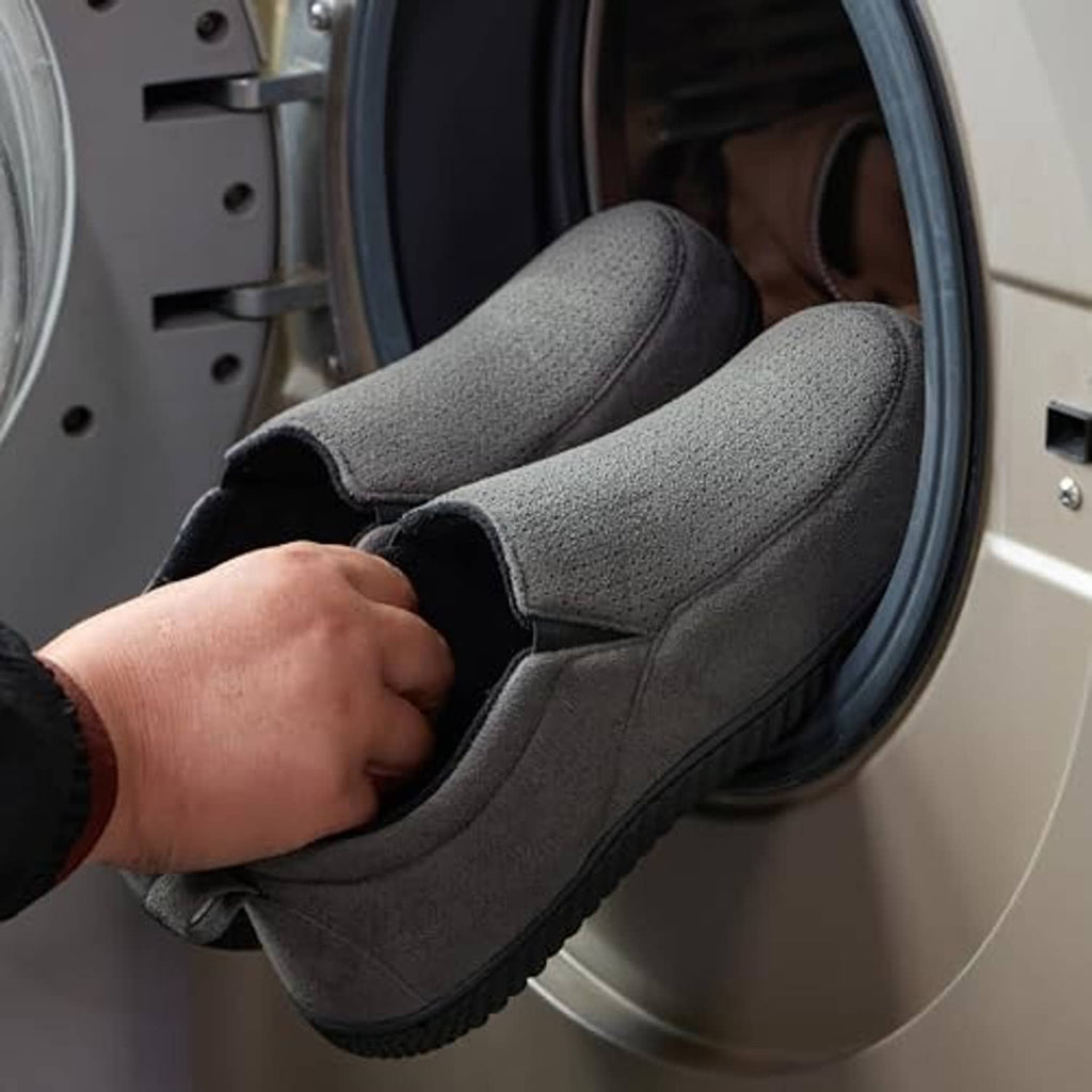 Charcoal closed-back slippers being put on, plush interior visible through opening.