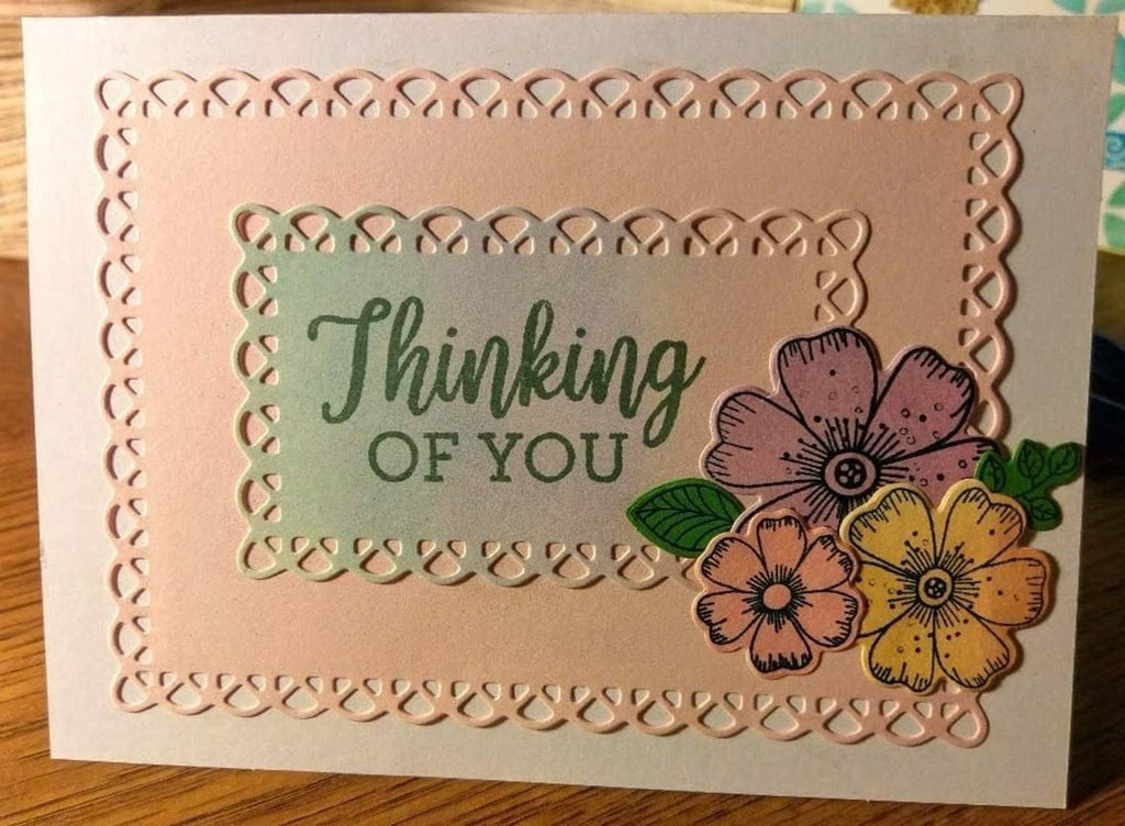 Scalloped rectangle frame die cutting a beige card with flowers and text