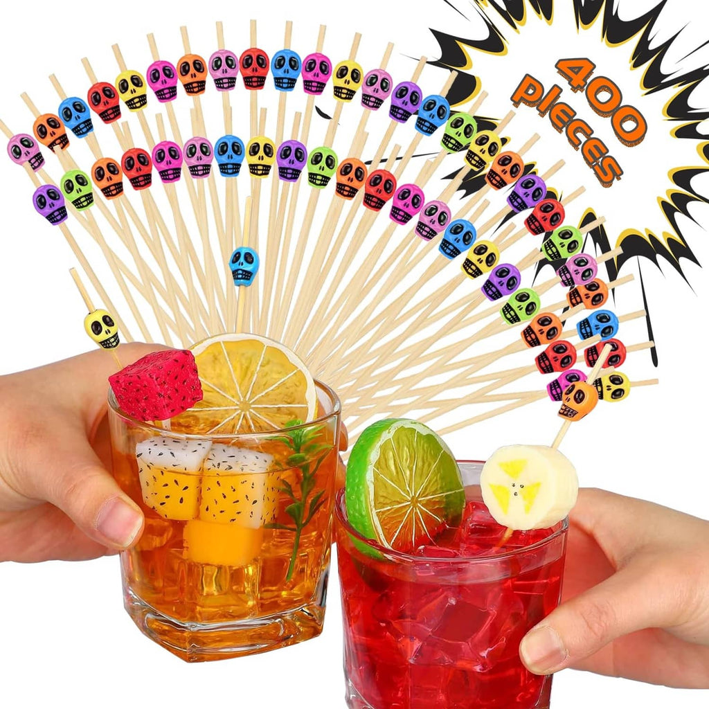 Colorful bamboo toothpicks with skull toppers, held over mixed drinks and fruit