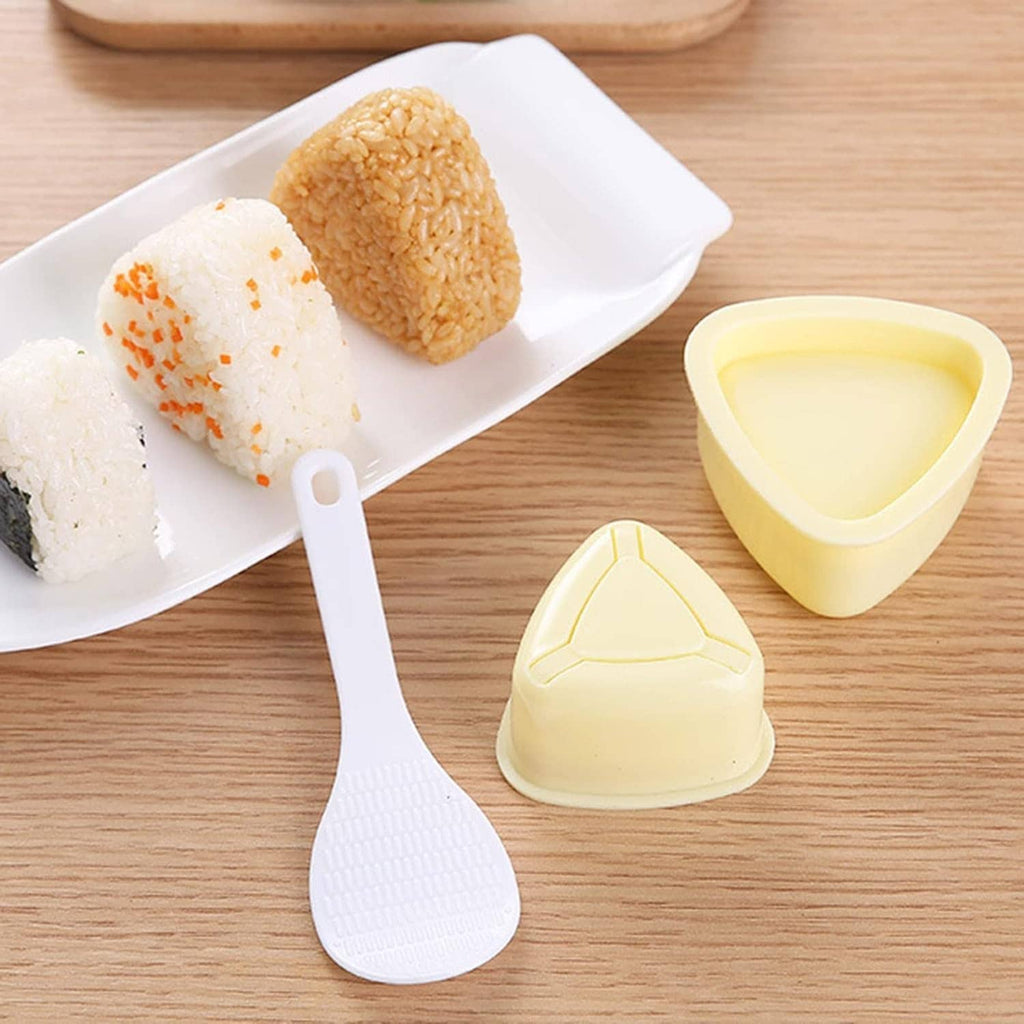 Onigiri triangle press molds with ridged white paddle, cream-yellow pieces on tray