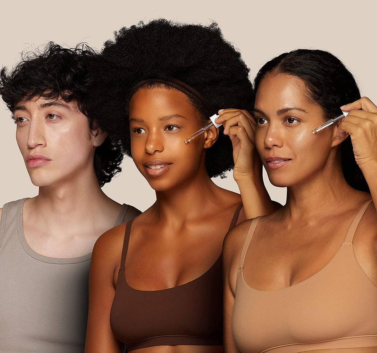 Skincare application scene with three people holding facial applicators for serum