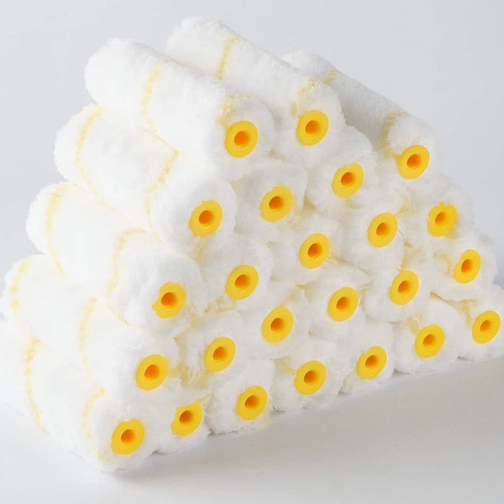 Close-up bundle of 4-inch paint roller covers with fluffy white nap and yellow cores