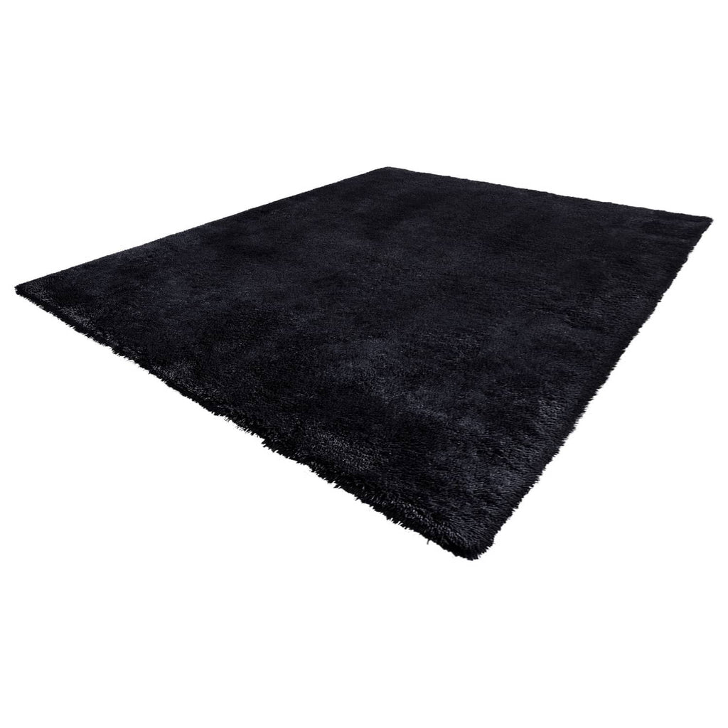 Black plush rectangular rug with dense shag pile and smooth, even surface