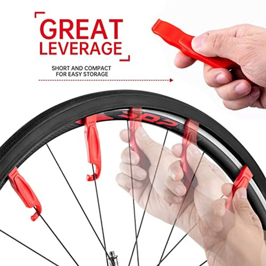 Hand holding a red tire lever while removing a black bicycle tire