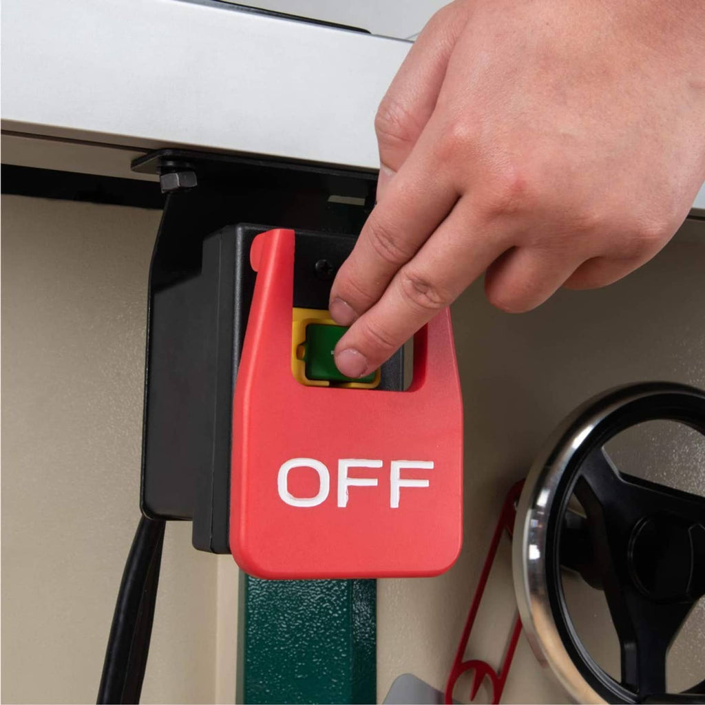Magnetic paddle switch being pressed by hand; red OFF paddle and green indicator