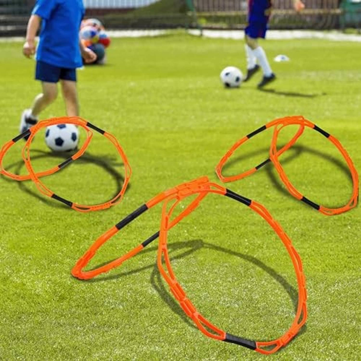 Orange octagonal agility rings on grass for youth footwork training.