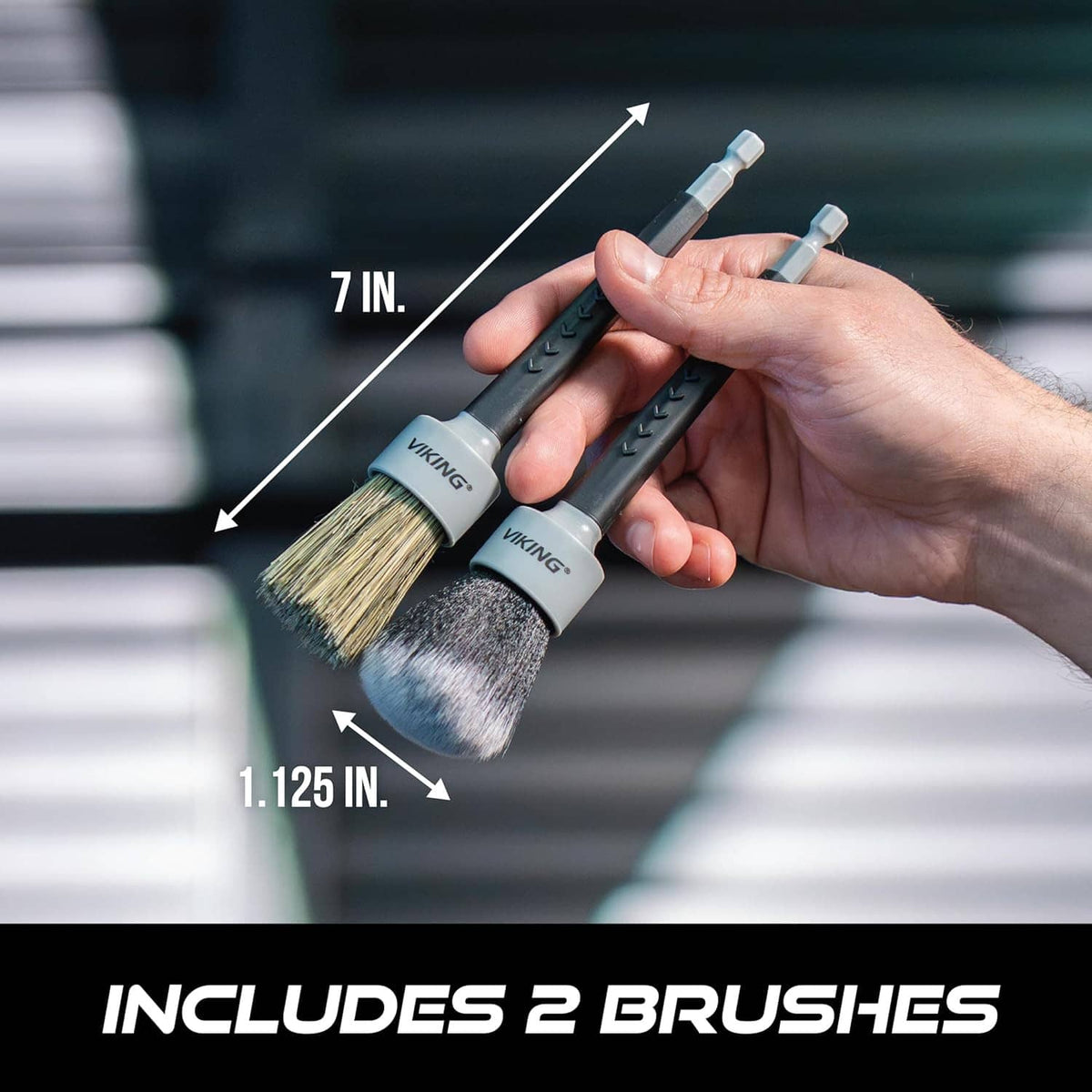 Two drill detail brushes held in hand, with gray and bronze bristle heads