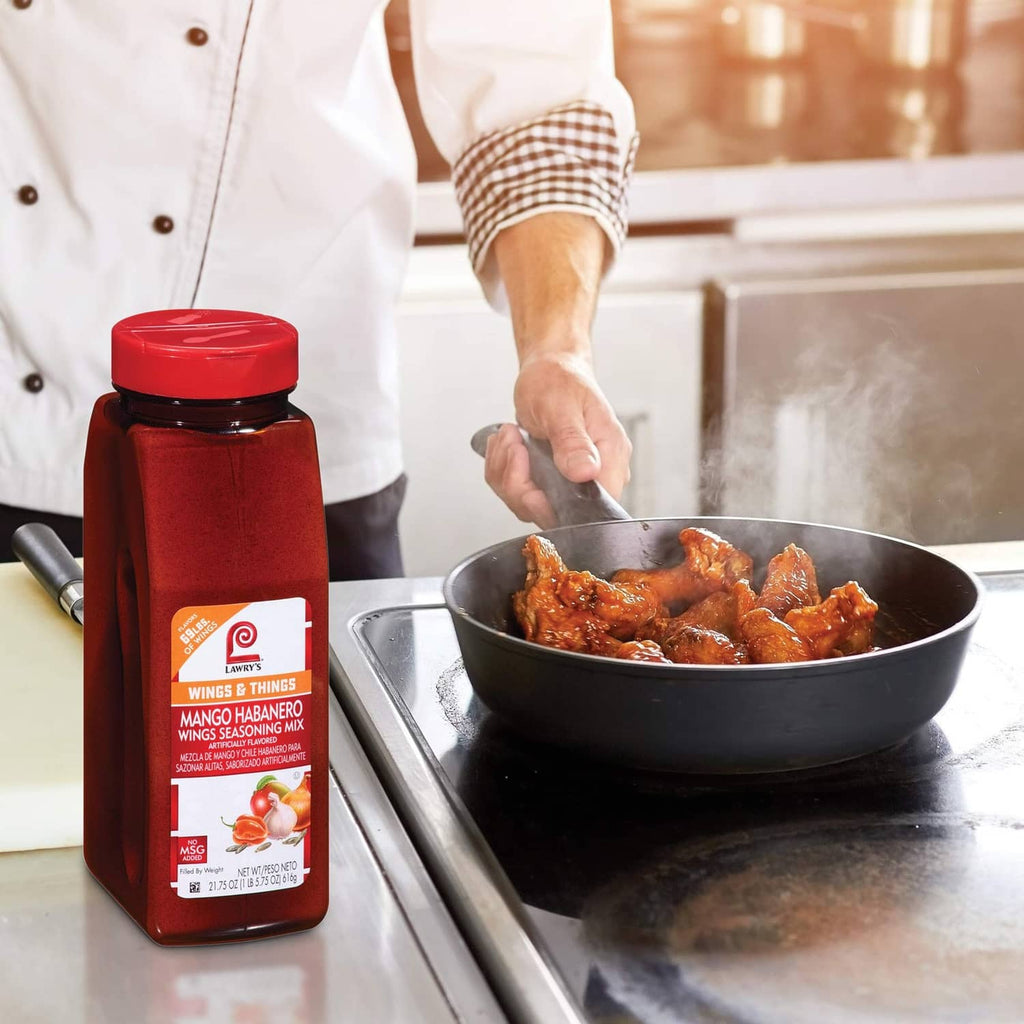 Lawry's Mango Habanero Wings Seasoning Mix bottle beside a bowl of sauced wings