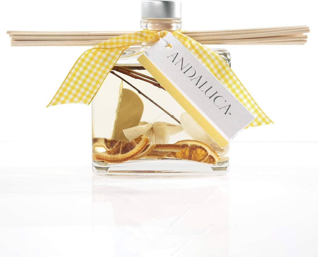 Clear reed diffuser bottle with light tan reeds, yellow gingham ribbon, and citrus spice accents
