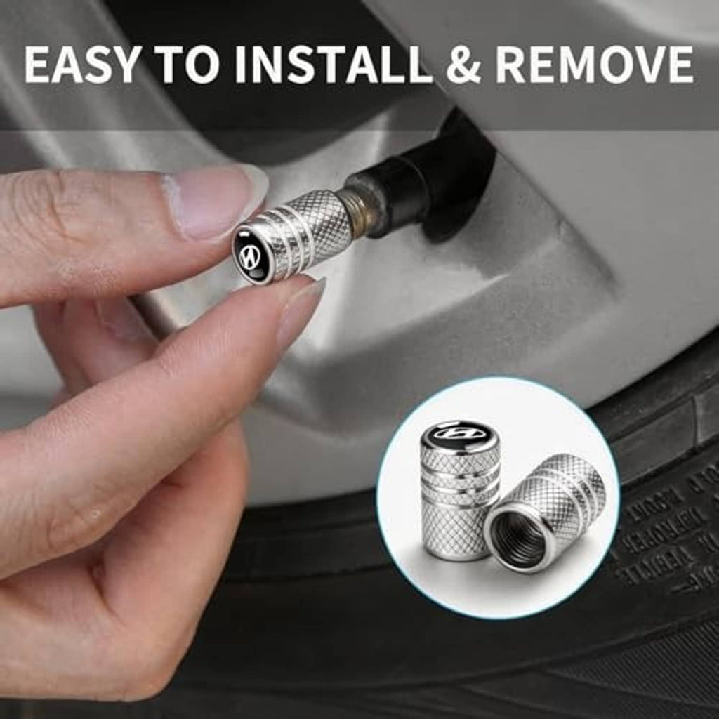 Hand installing silver textured tire valve stem dust cap onto a car wheel valve.