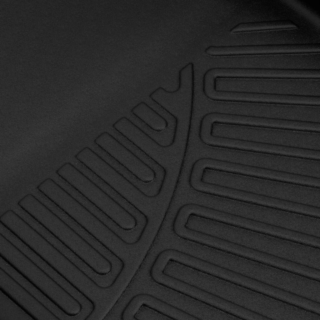 Black floor mat close-up with molded grip ridges and channel grooves