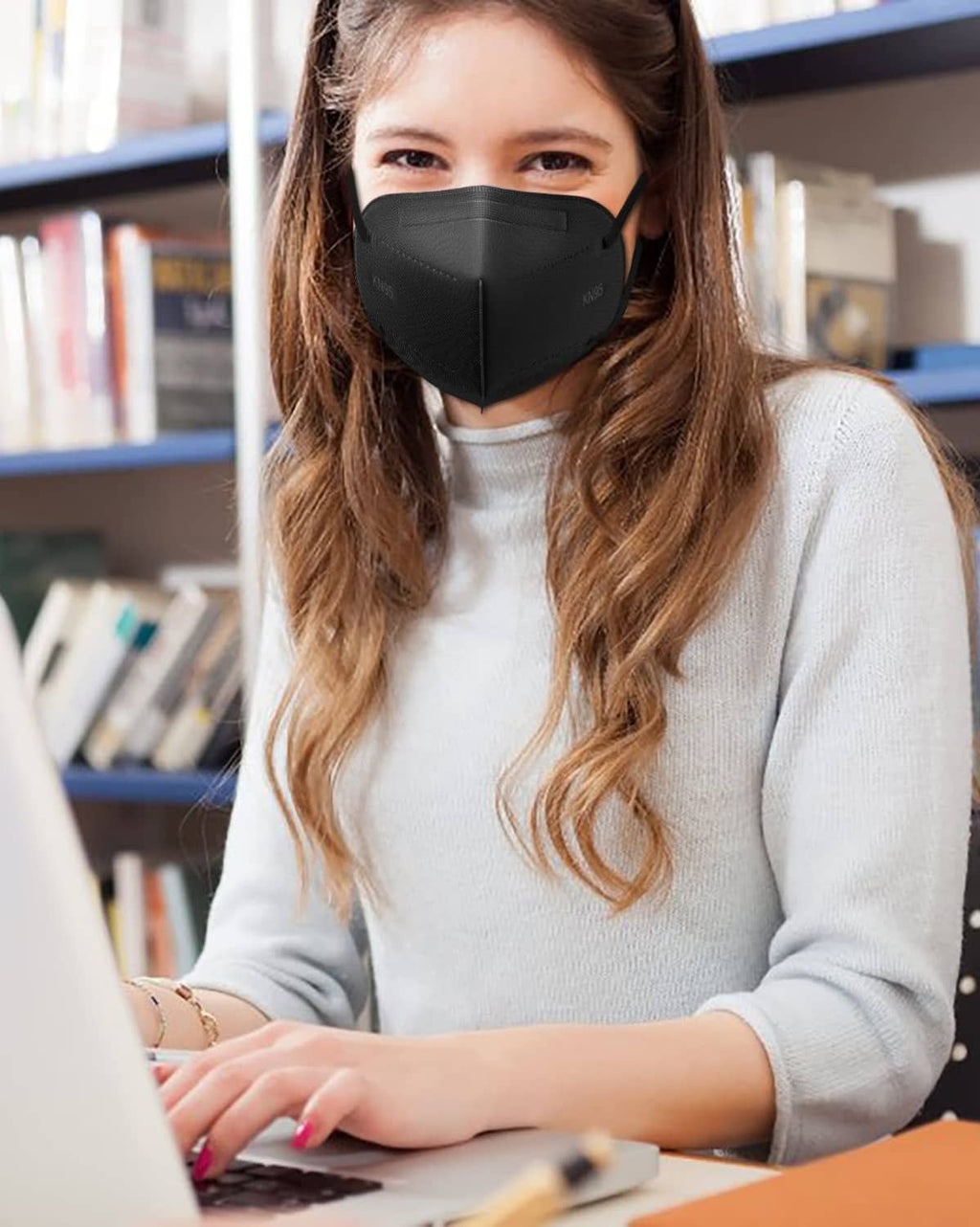 Black KN95 face mask worn by person, front view with ear loops