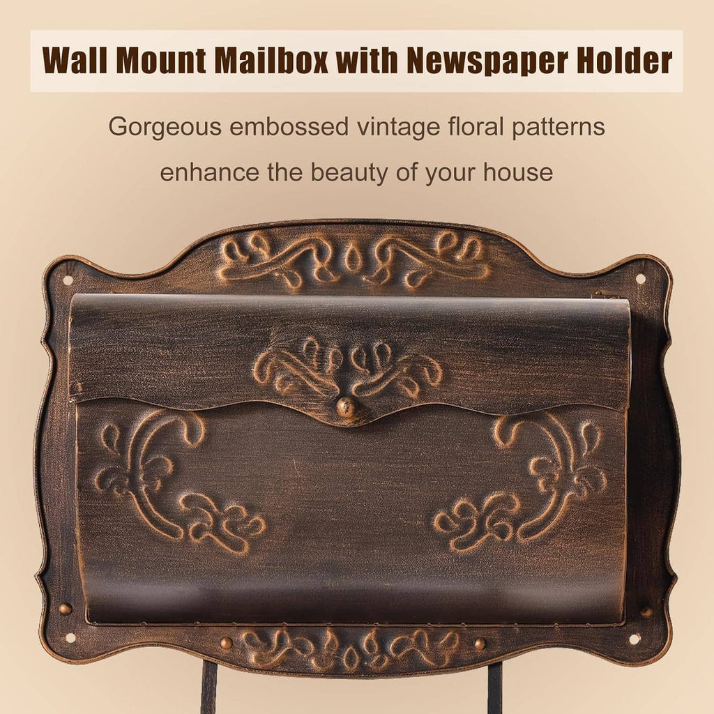 Dark bronze wall-mount metal mailbox with embossed floral crest and newspaper holder
