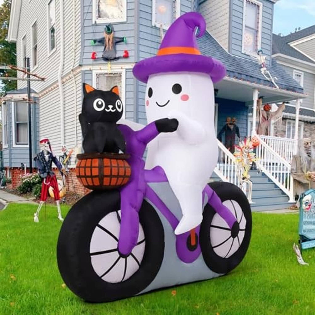 Outdoor inflatable ghost cycling: purple hat, black wheels, and cat with pumpkin basket