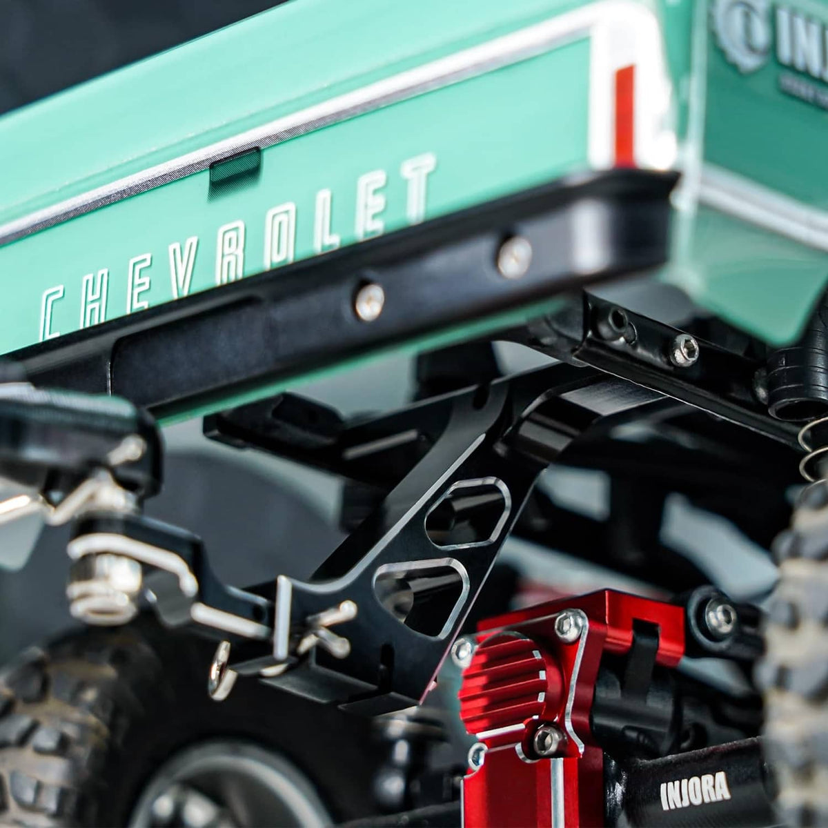 Black RC trailer hitch mount with metal bracket, bolts, and mounting hardware
