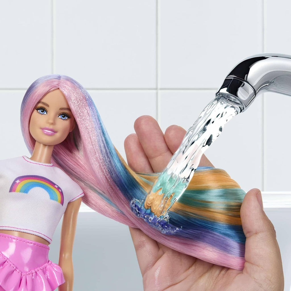 Rainbow sparkle hair doll with pink top, showing long pastel hair being brushed by a hand.