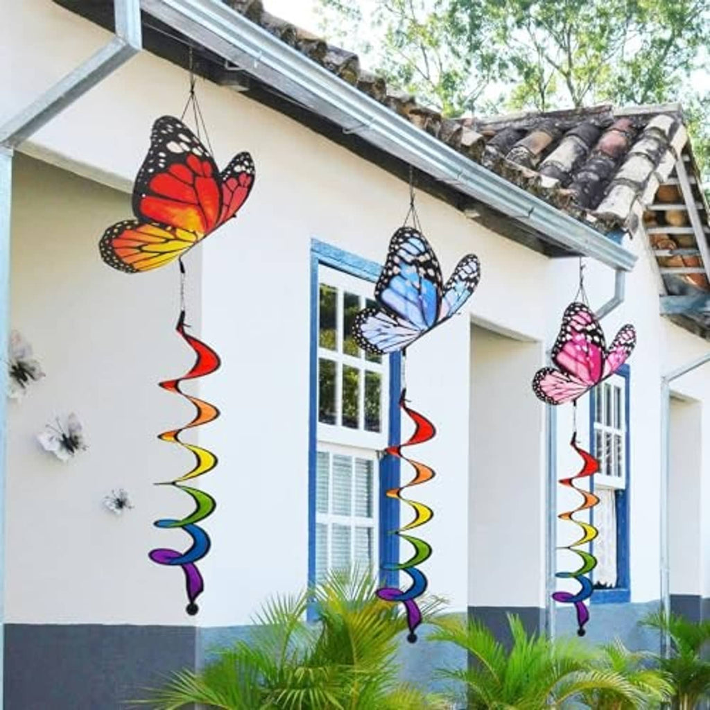 Three butterfly wind spinners hanging from above with spiral ribbon tails
