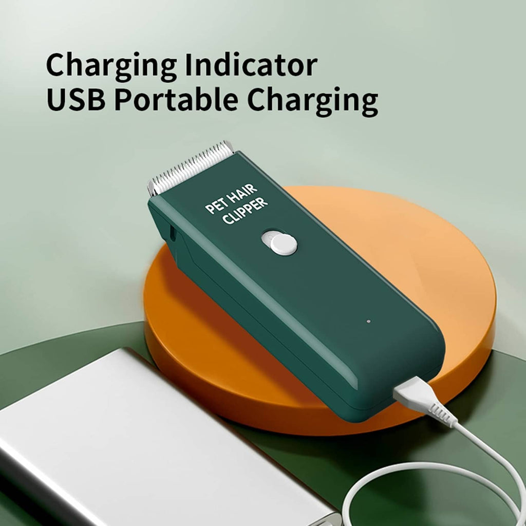 Green USB portable pet hair clipper charging with indicator light on tabletop