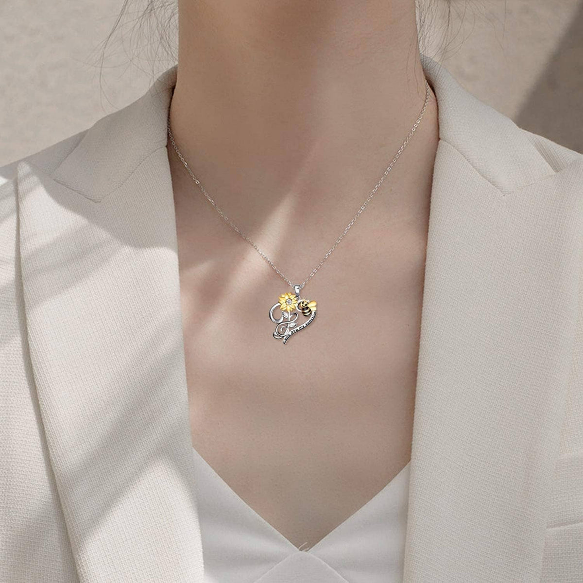 Silver-tone heart pendant necklace with small bee and flower charm