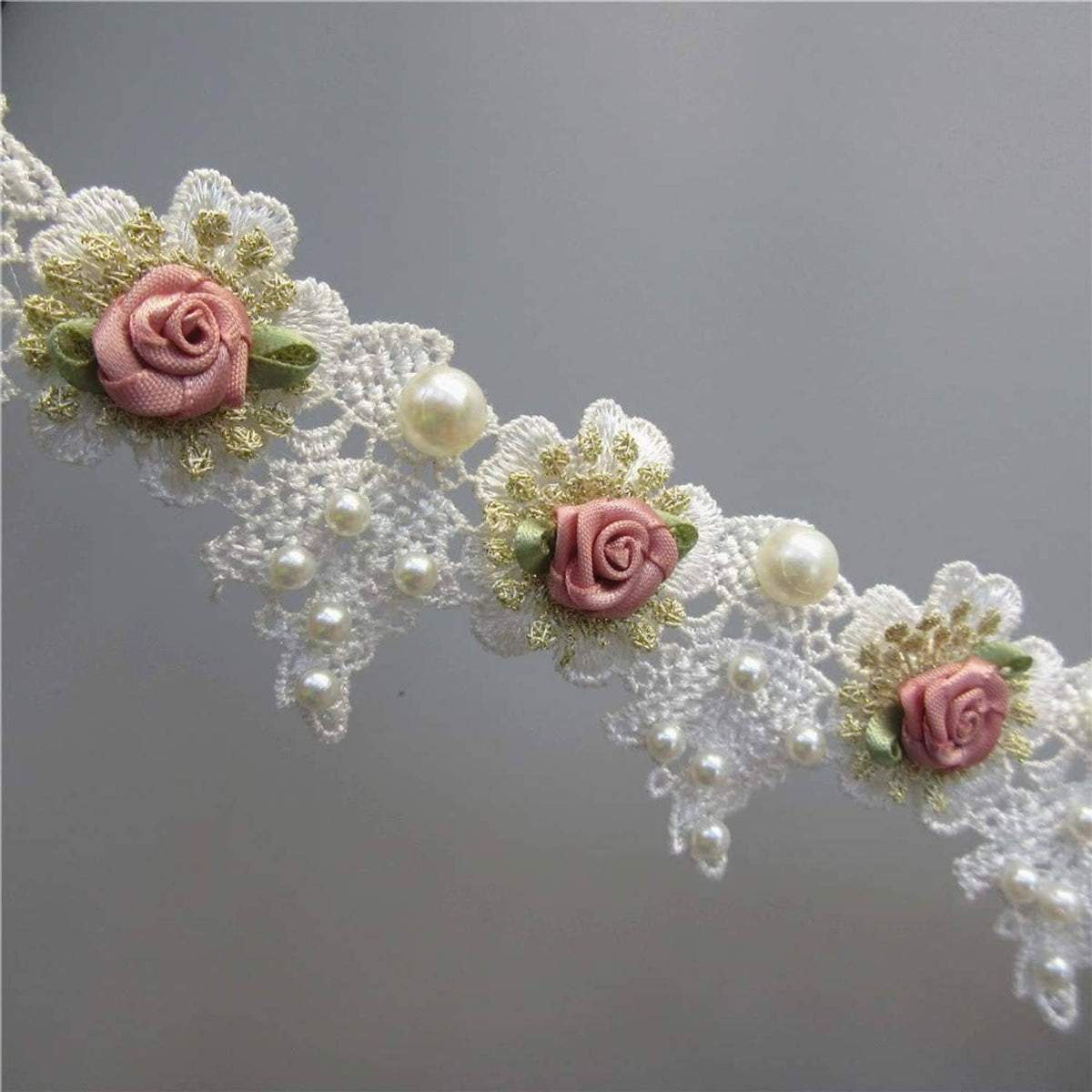 White lace trim with pink rose flowers and pearl beads along the trim edge