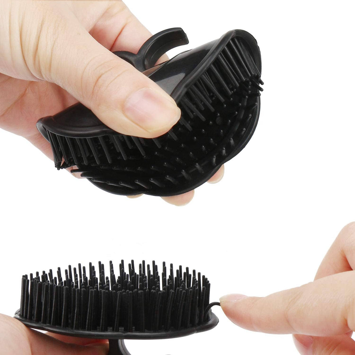 Black scalp massage brush shown in hand with dense bristles on oval pad