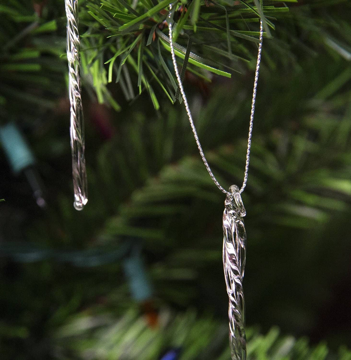 Clear glass icicle ornament tip detail with twisted ridges and silver-tone loop