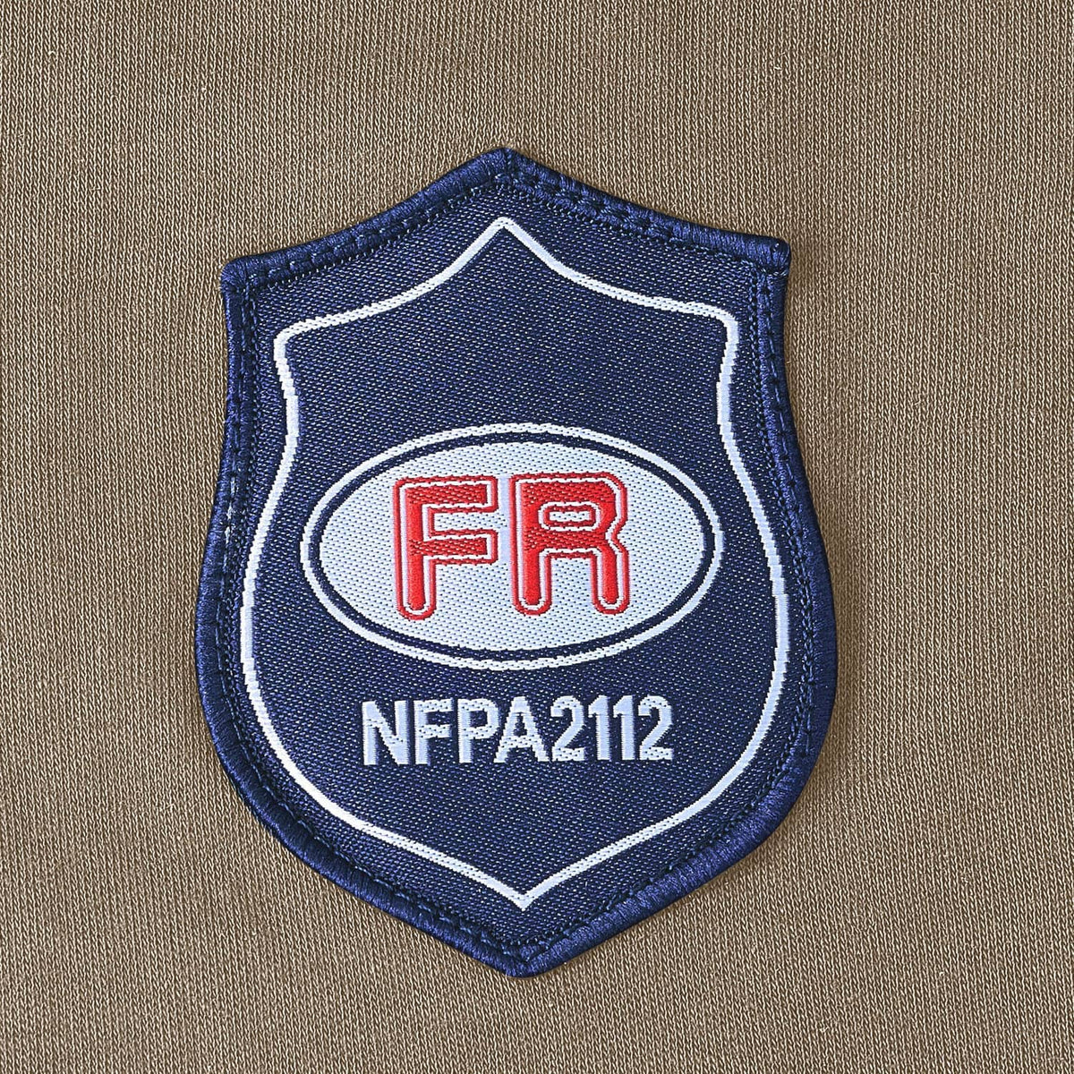 Flame-resistant work shirt FR NFPA 2112 shield patch on gray fabric