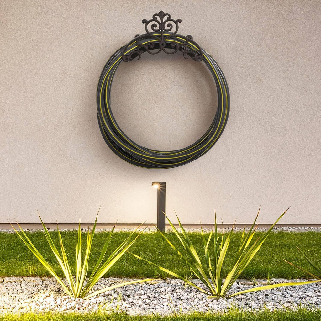 Decorative wall hose hanger with coiled multicolor garden hose in a circular loop shape.