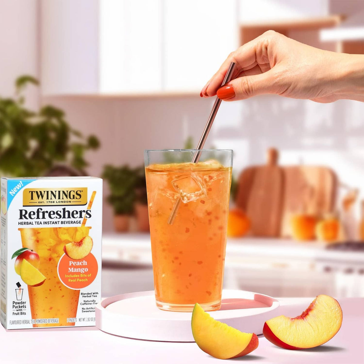 Instant herbal tea mix box beside a tall glass of peach mango flavored drink