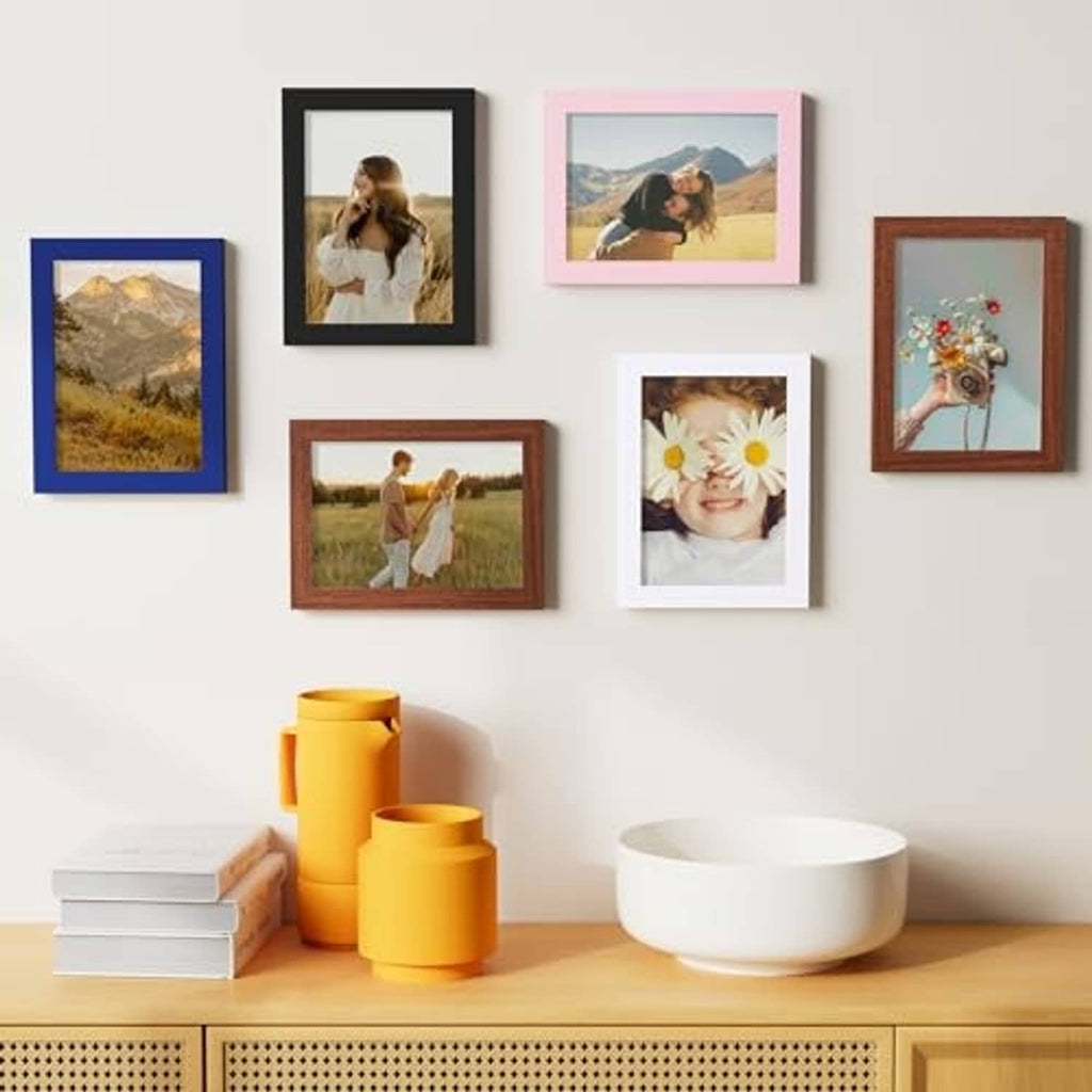 Multiple 5x7 picture frames on a wall with black, brown, and blue borders.