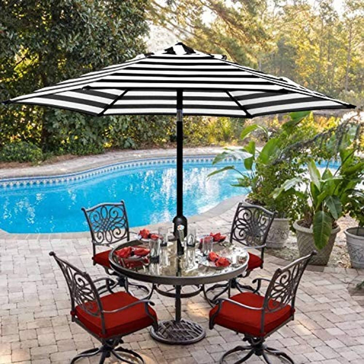 Black-and-white striped patio umbrella open over outdoor patio dining set