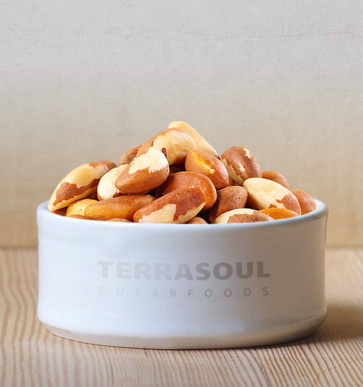 Bowl of raw whole Brazil nuts with Terrasoul Superfoods logo