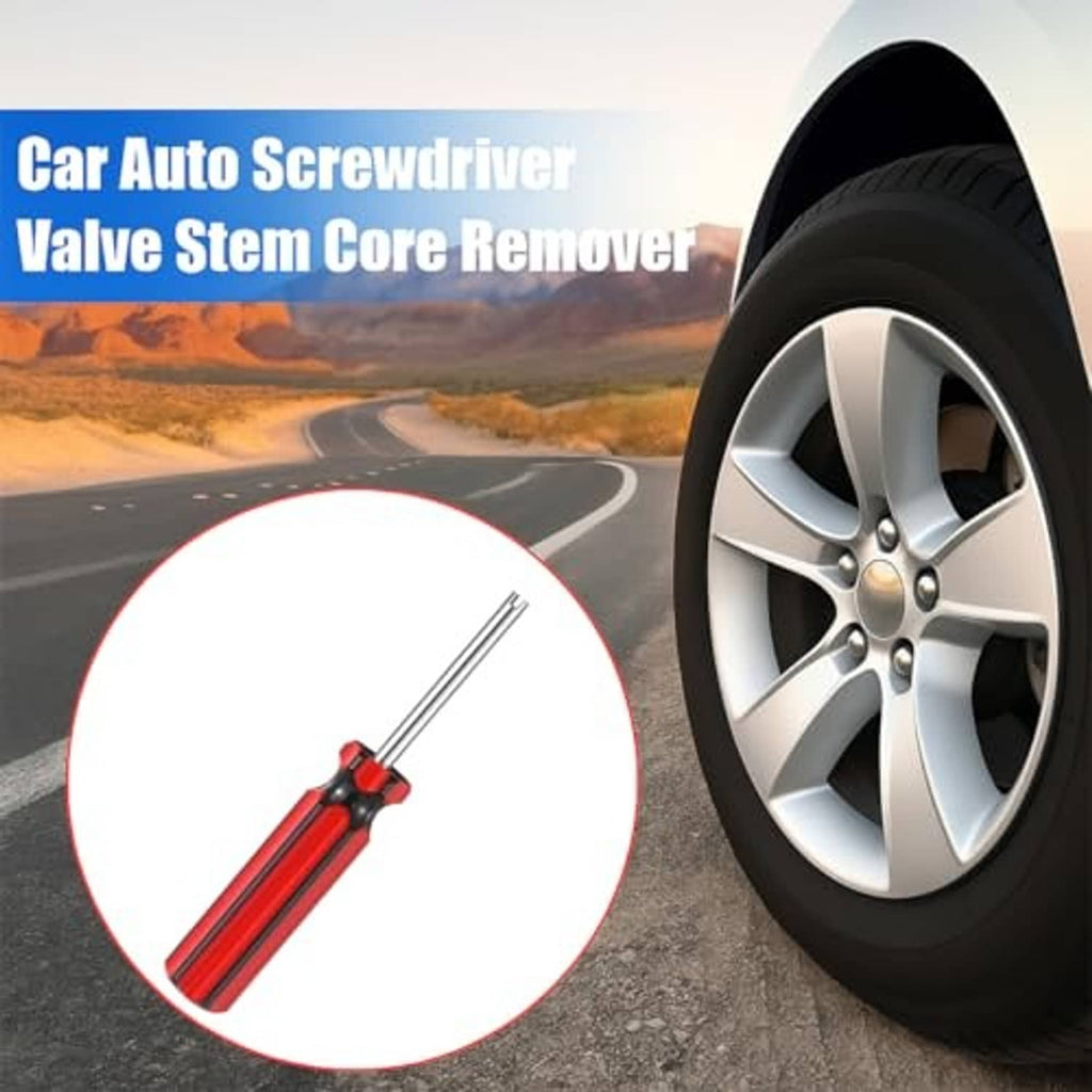 Red-and-black tire valve core remover tool near a wheel