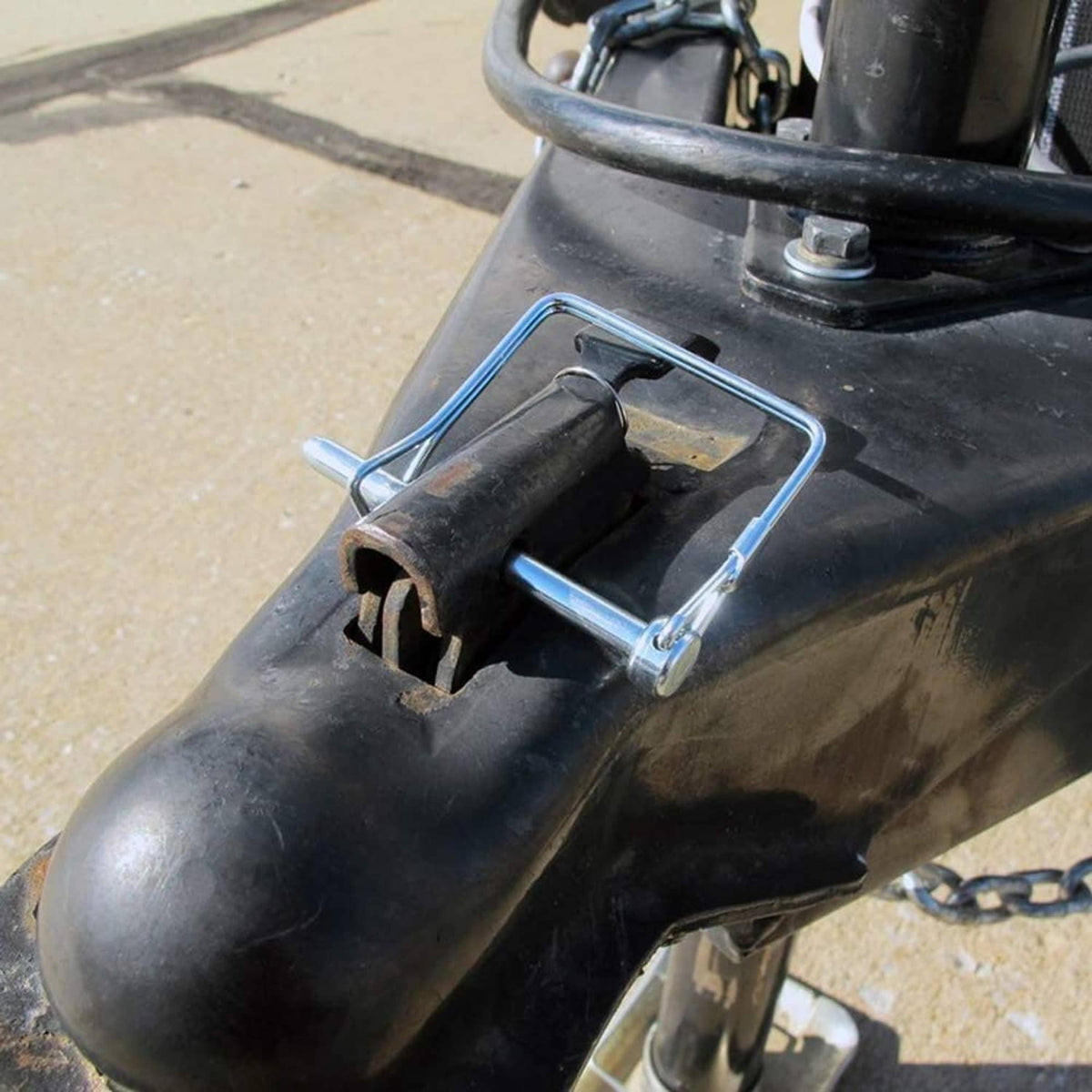 Wire lock pin securing a trailer coupler shank on a metal frame