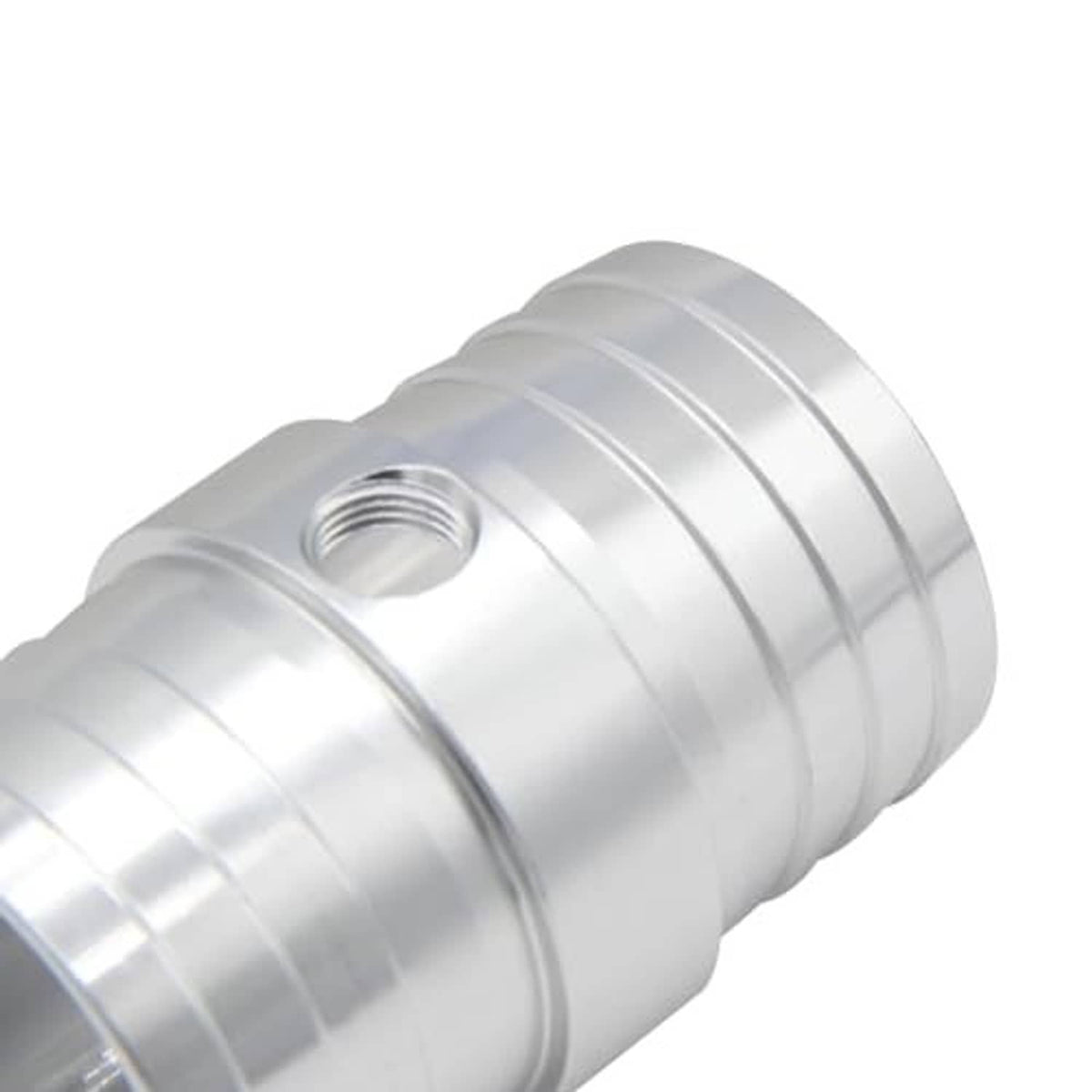 Close-up of radiator hose barb adapter body with band seams and threaded NPT port, silver.