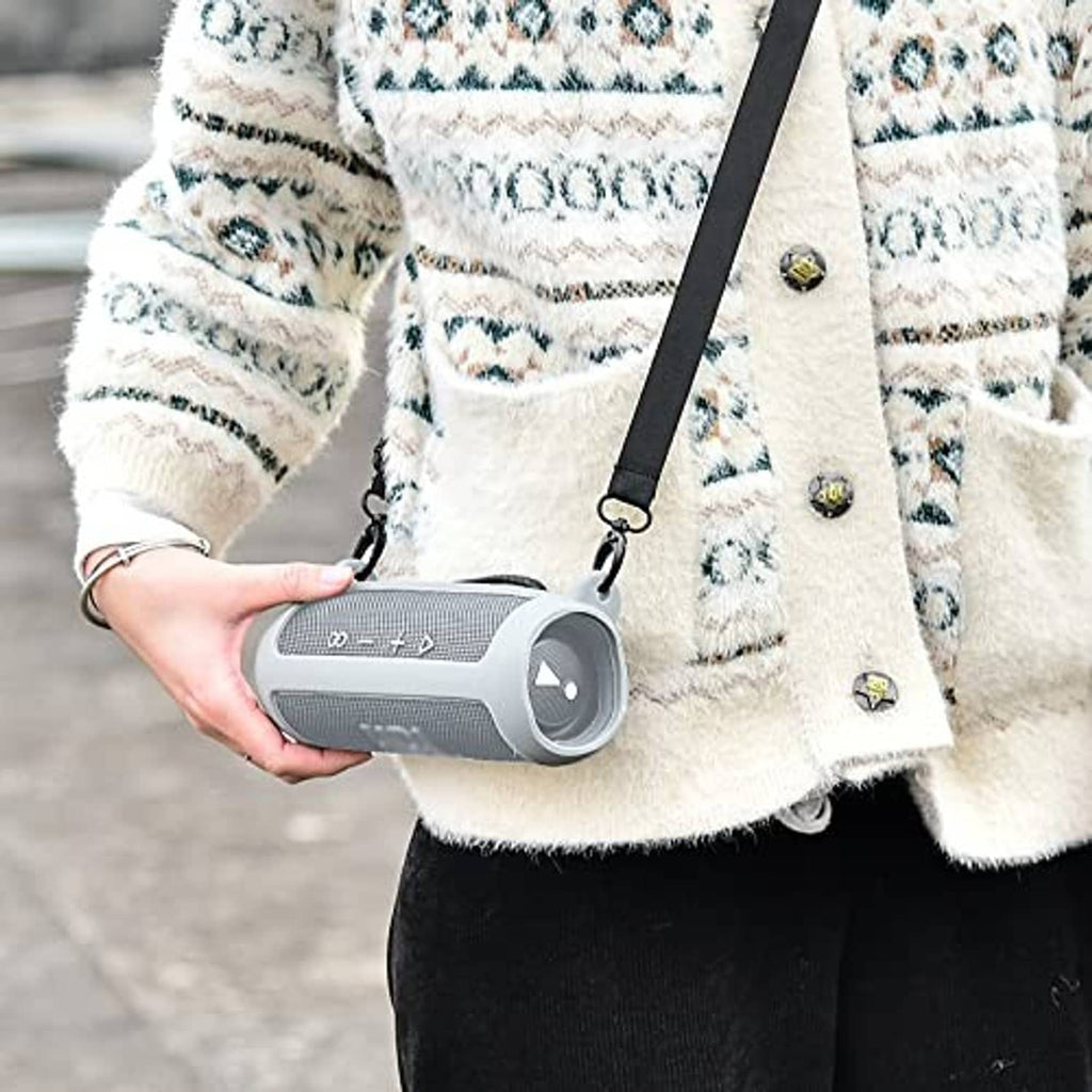 Gray silicone speaker case worn with strap, holding a portable Bluetooth speaker
