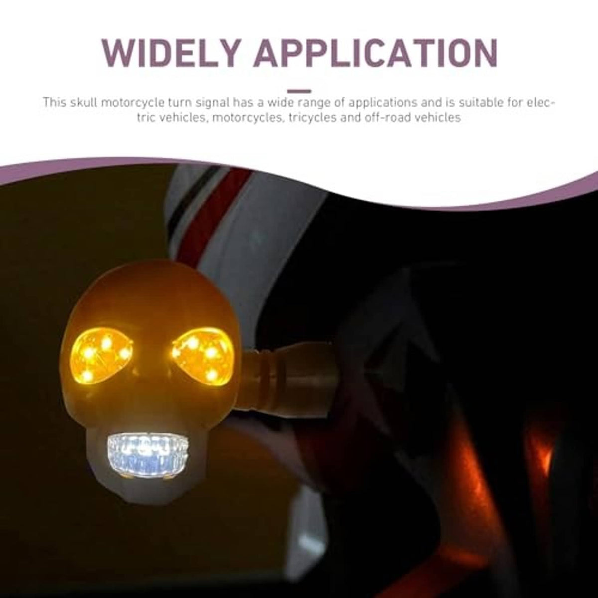 Amber and white skull-shaped LED turn signal light mounted on a motorcycle