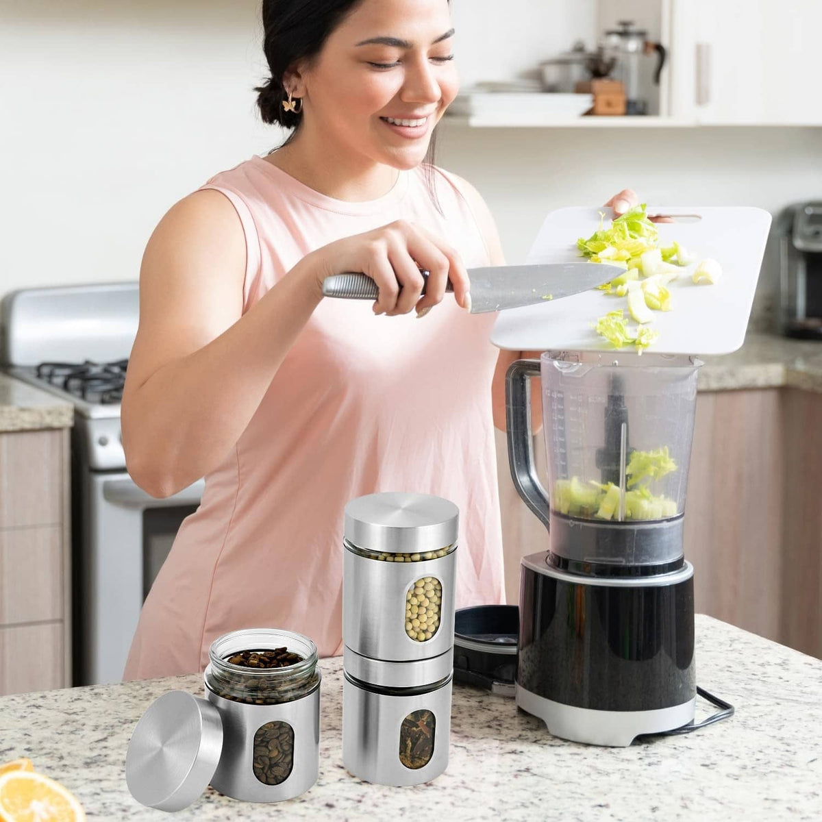 Stainless steel canister set with clear windows, shown upright on a kitchen counter