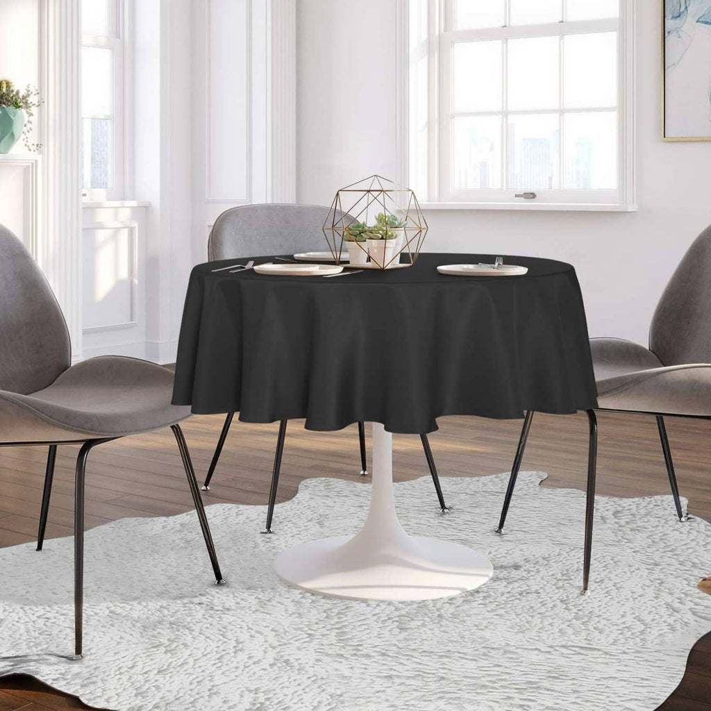 Black round tablecloth covering a dining table, smooth skirt