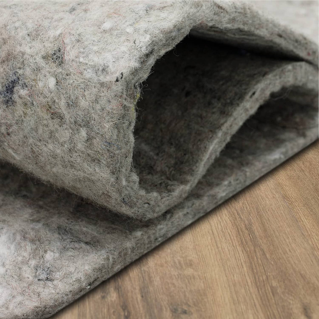 Edge view of gray felt rug pad showing thick cushioning and dense felt layers