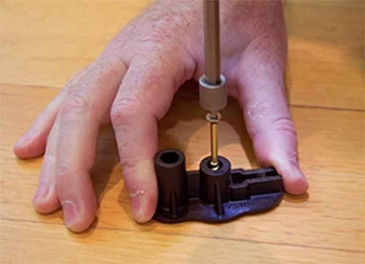Snap base secured on hardwood floor with driver tool and screw head