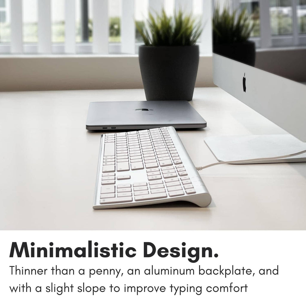 Silver full-size wired keyboard with white keycaps on an aluminum platform