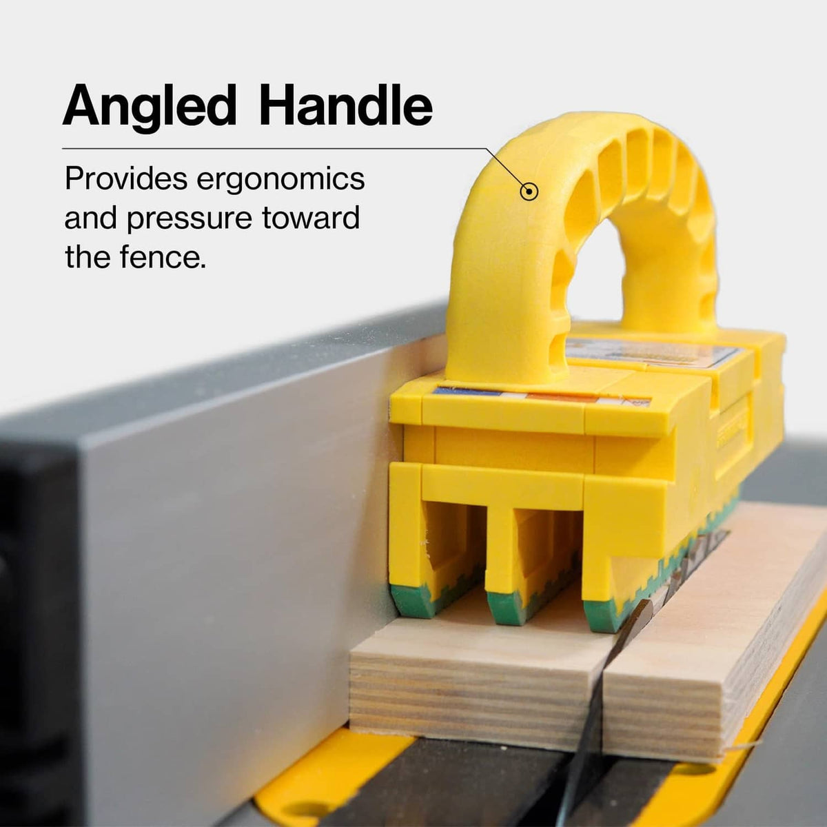 Angled yellow router push block with arched handle and green toothed insert