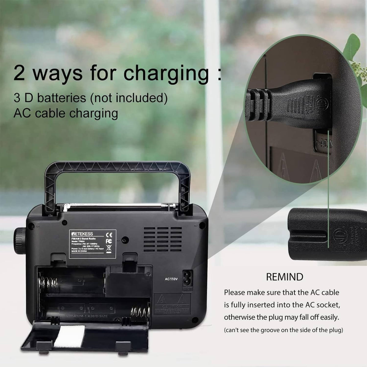Portable AM/FM radio with open battery compartment and charging ports on the back