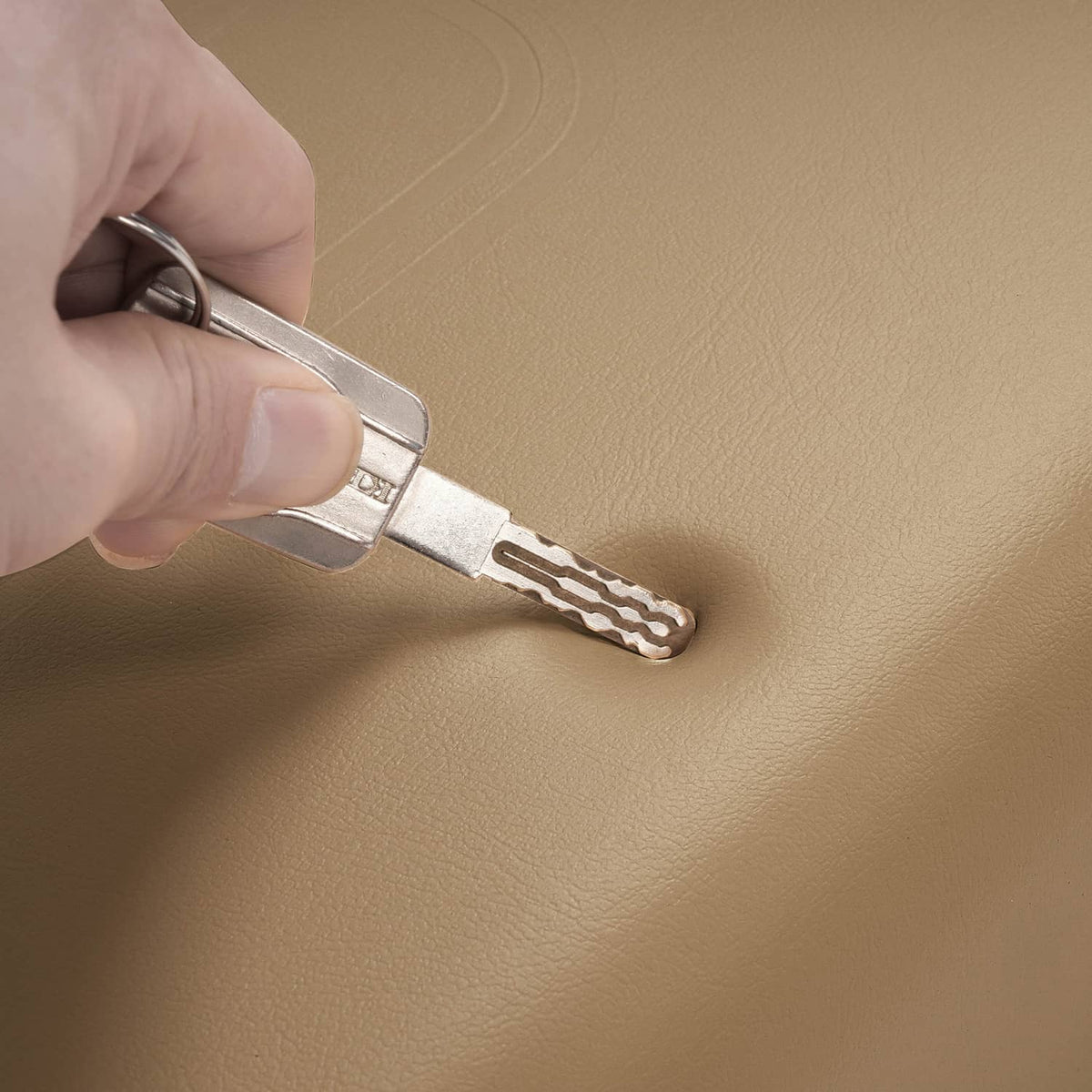 Tan cushion surface with metal latch key inserted for fastening