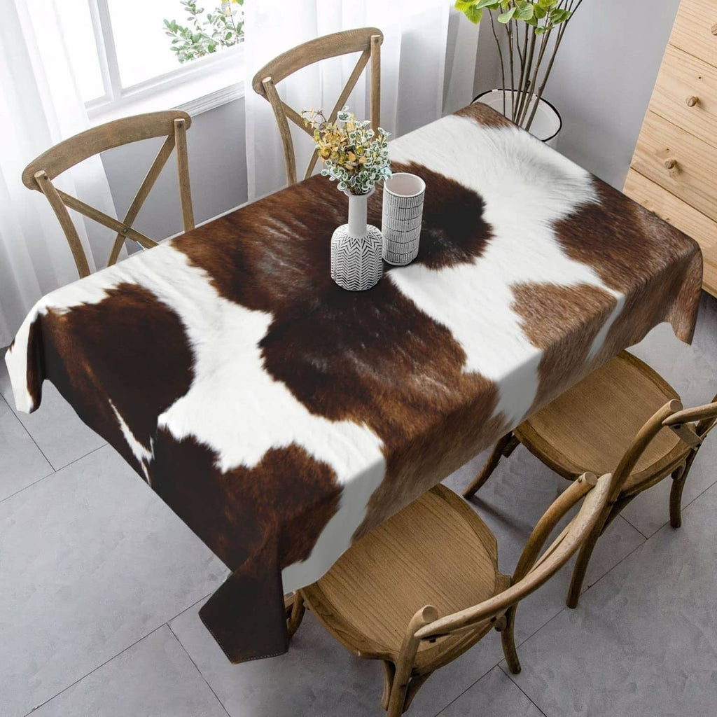 Brown and white cowhide-pattern tablecloth covering dining table, overhang on sides